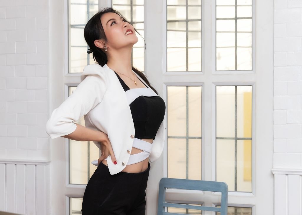 A businesswoman stretching her back to fix her posture imbalance.