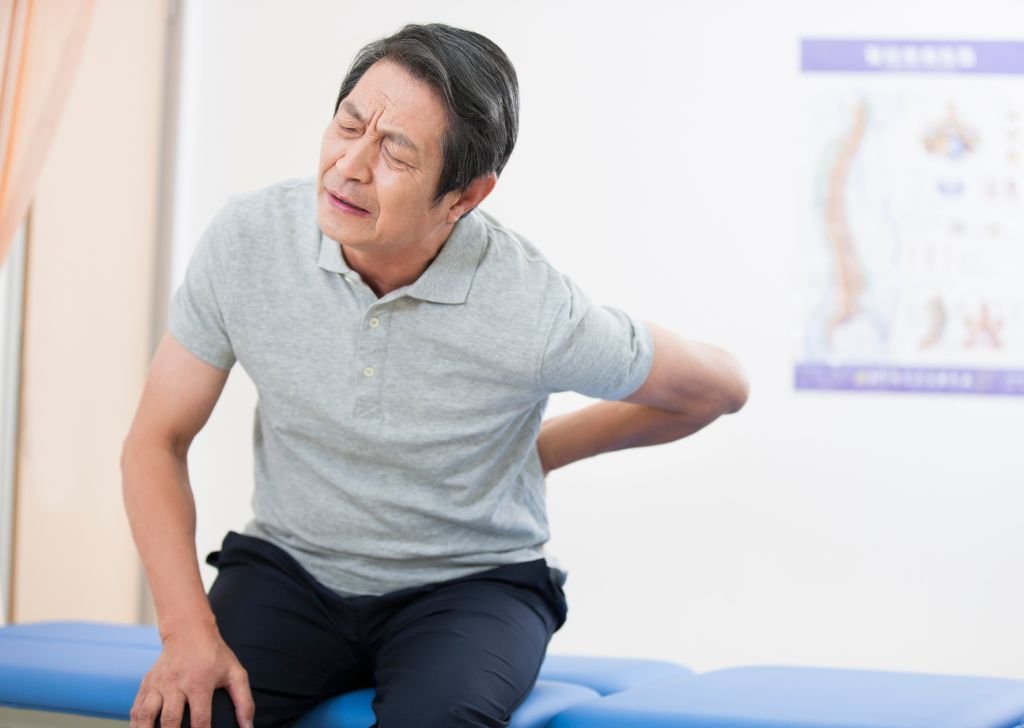 A man suffering from back pain caused by Sciatica.