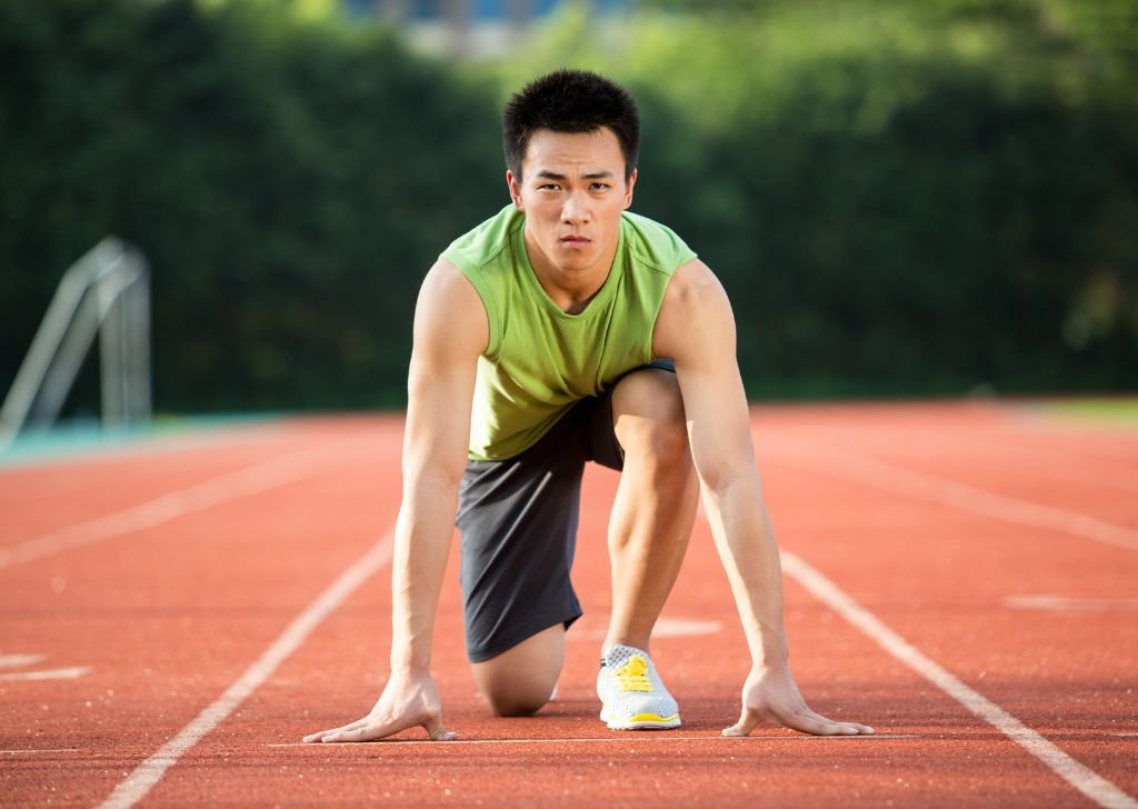 A runner athlete preparing to sprint on the track.