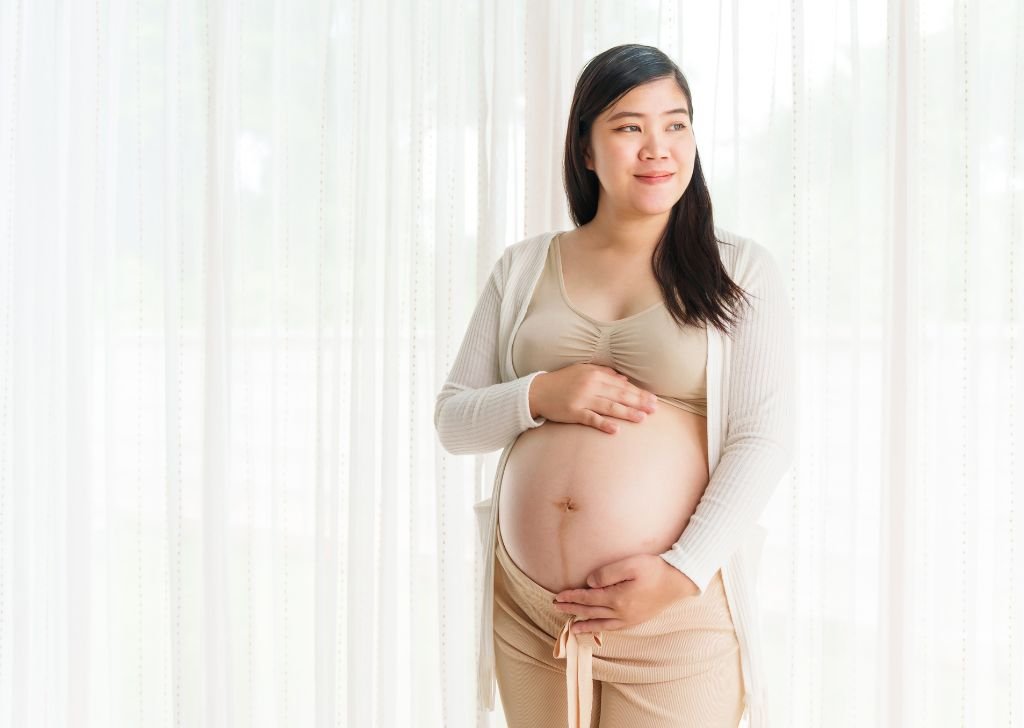 A pregnant Asian woman posing.