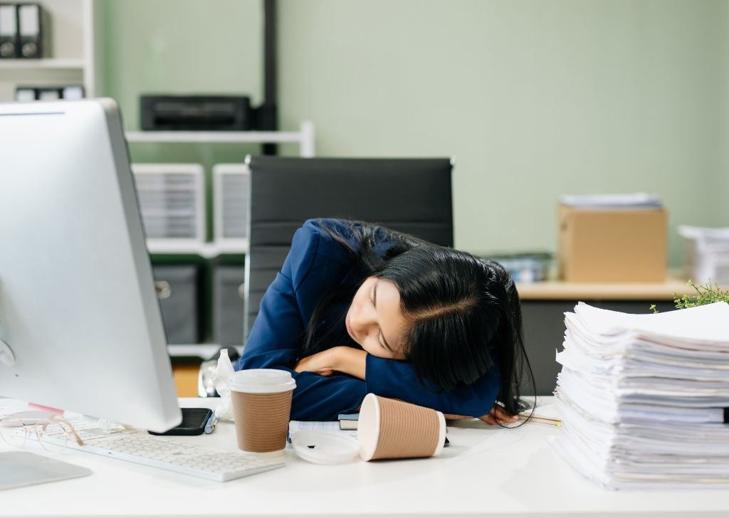 An office worker stressed out on her table.