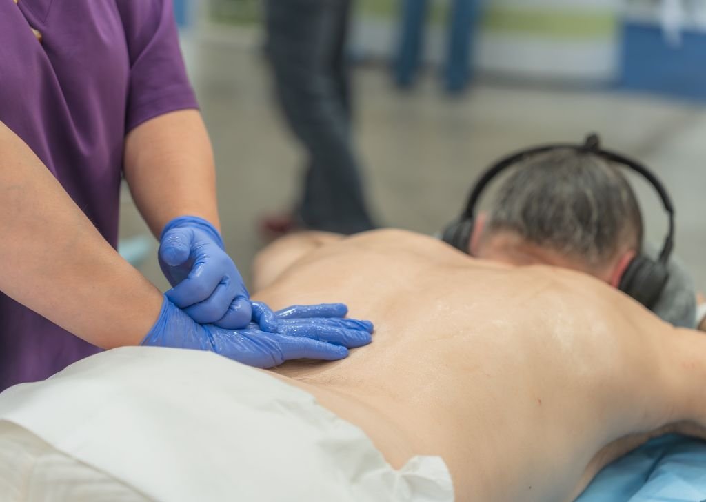 A chiropractor in Petaling Jaya massaging a patient's back.