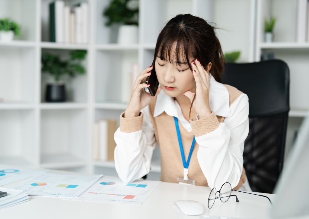 An Asian office worker stressed out.