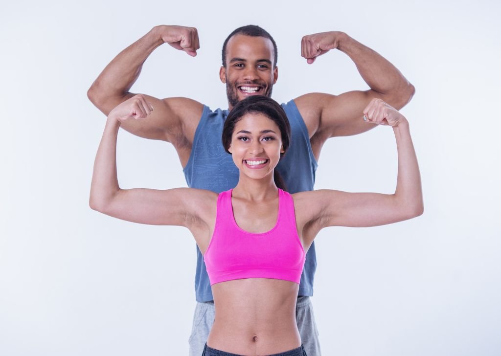 A happy couple flexing their muscles.