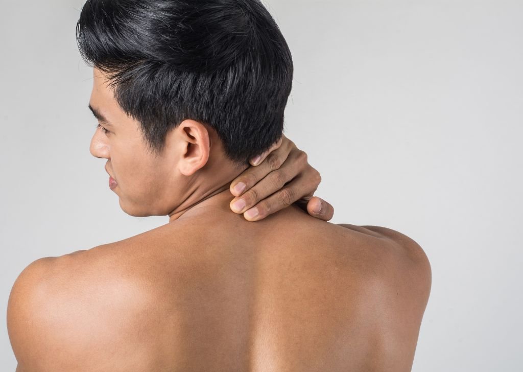 A male patient suffering from neck and back pain caused by a slipped disc.