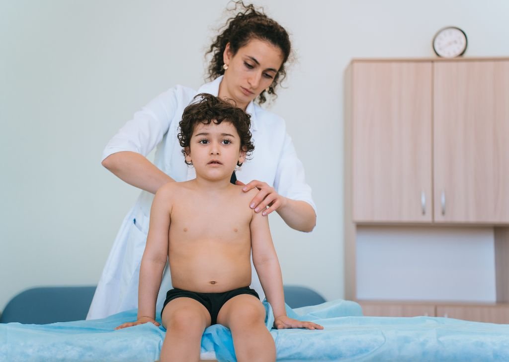 A physiotherapist checking a boy's spine in Petaling Jaya.