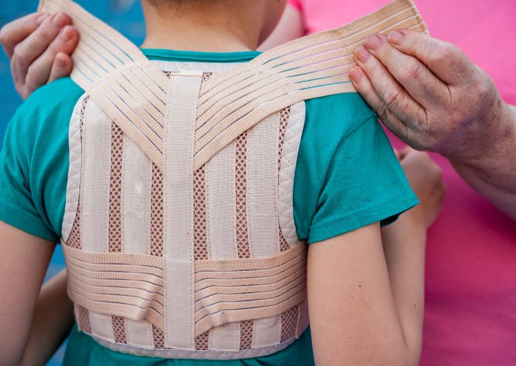 A physiotherapist fitting a back brace to a child at Petaling Jaya.