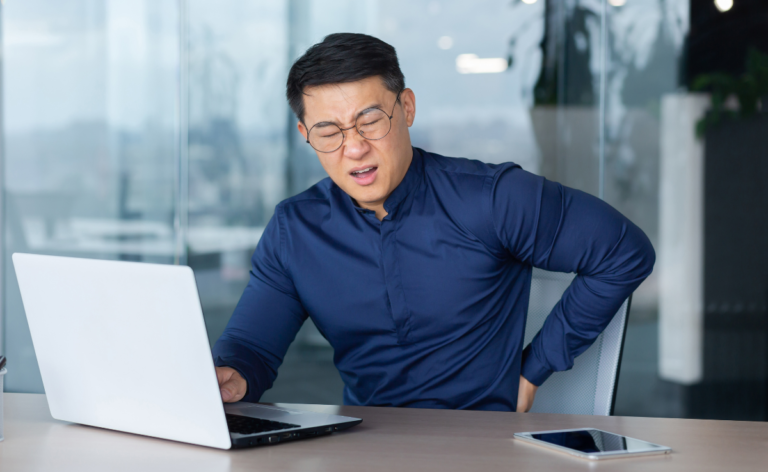 Asian man having backpain after long hours of doing office work