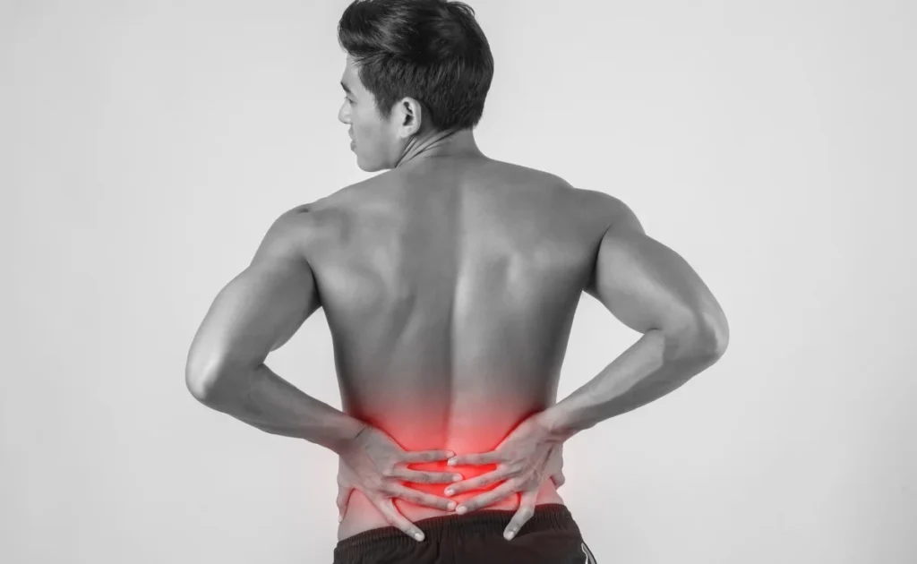 Fit young man having hip and back pain from heavy lifting. 