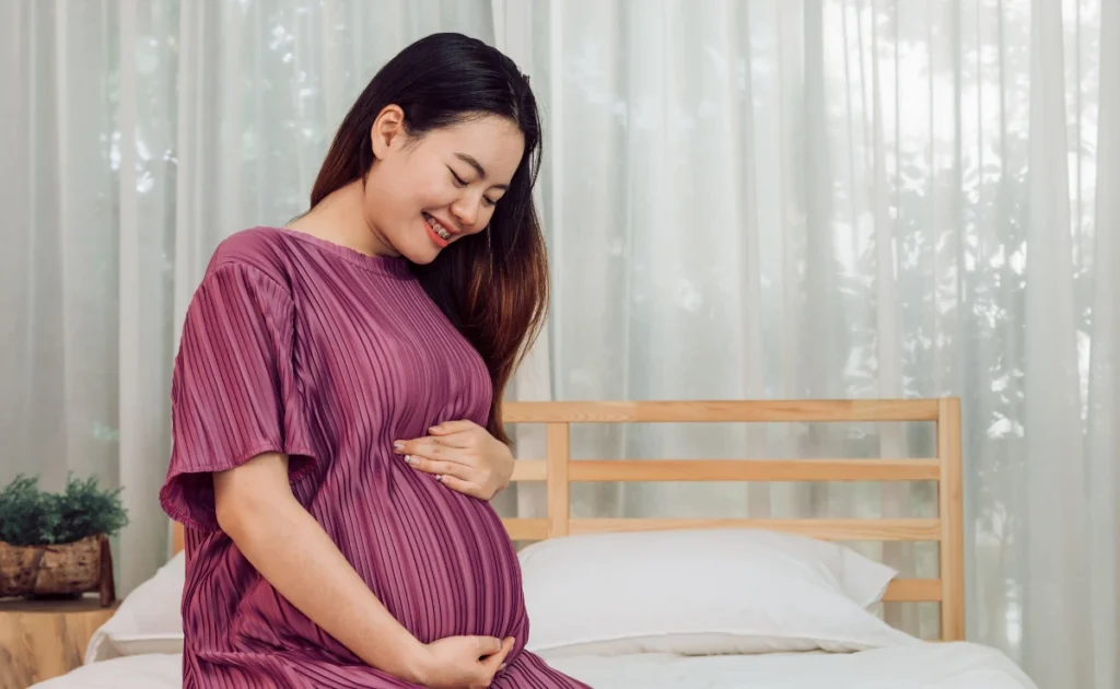 A pregnant woman in her bedroom.