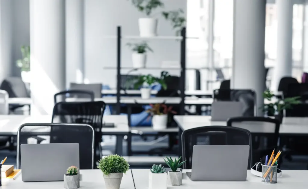 A co working space with plenty of tables and office chairs. 